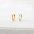 Kris Nations twisted hinged huggie hoop earrings in 18k gold vermeil